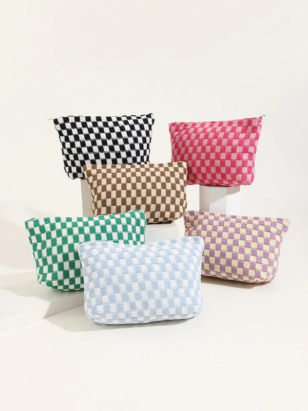 A set of five checkered fabric makeup organizer bags in black, pink, brown, green, and blue are displayed on a white surface.