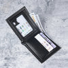 A black slim leather wallet with an eagle design is shown open, displaying credit cards and cash.