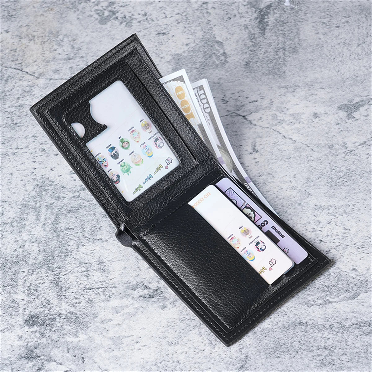 A black slim leather wallet with an eagle design is shown open, displaying credit cards and cash.