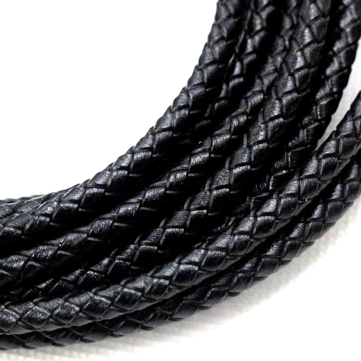 A close-up of black braided leather cord used for jewelry making.