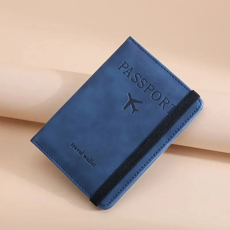 A dark blue passport wallet with black trim is shown diagonally on a light beige surface.