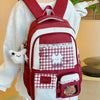 A maroon backpack with white and red checkered fabric accents worn by a person.