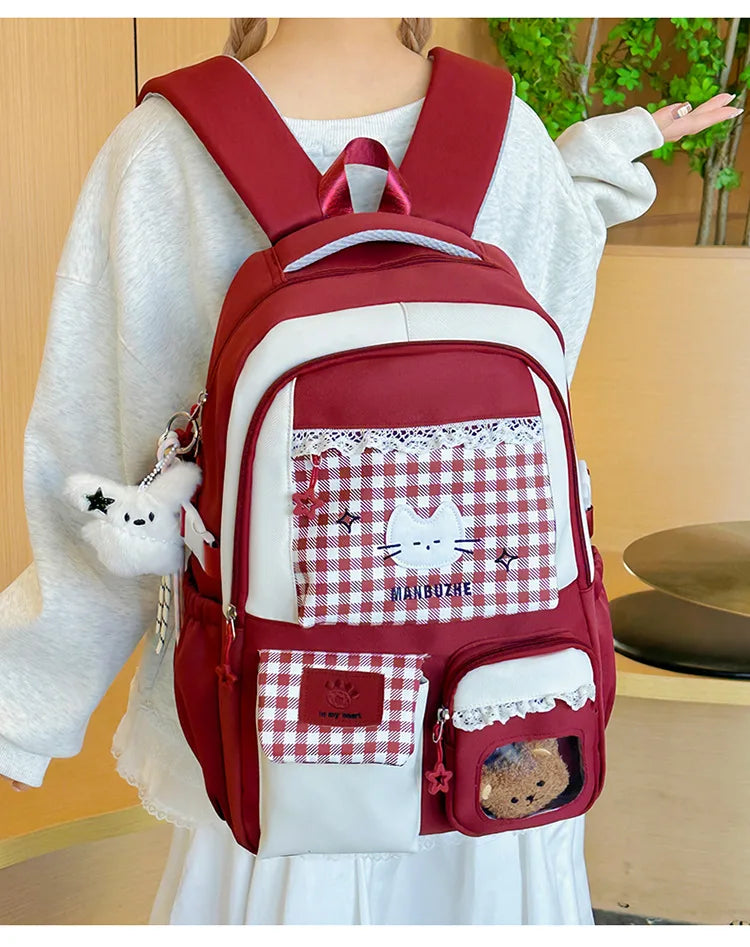 A maroon backpack with white and red checkered fabric accents worn by a person.
