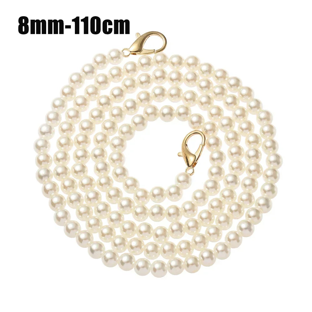 A strand of small, round cream-colored pearls on a gold-toned strap for a handbag or purse.