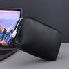 Black leather multi-layer cable organizer pouch next to a laptop.