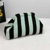 A black and light green striped knit cloud makeup bag is shown on a white surface.