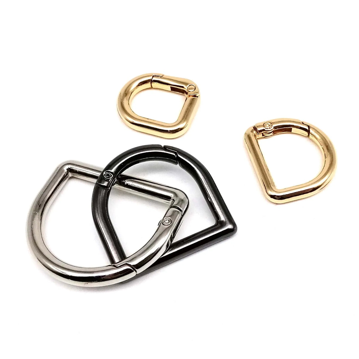 Three metal spring ring clasps in gold and silver finishes displayed against a white background.