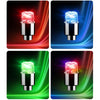 A set of four LED tire valve stem lights shown in various colors: red, blue, green, and purple.