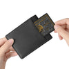 A black leather wallet with an embossed card is held by a hand.