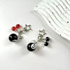 A silver and black Y2K 8 ball keychain with red accents and a star charm resting on a white background.