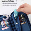 A hand opens a blue corduroy pencil case to show an independent inner pocket containing a clear correction tape.