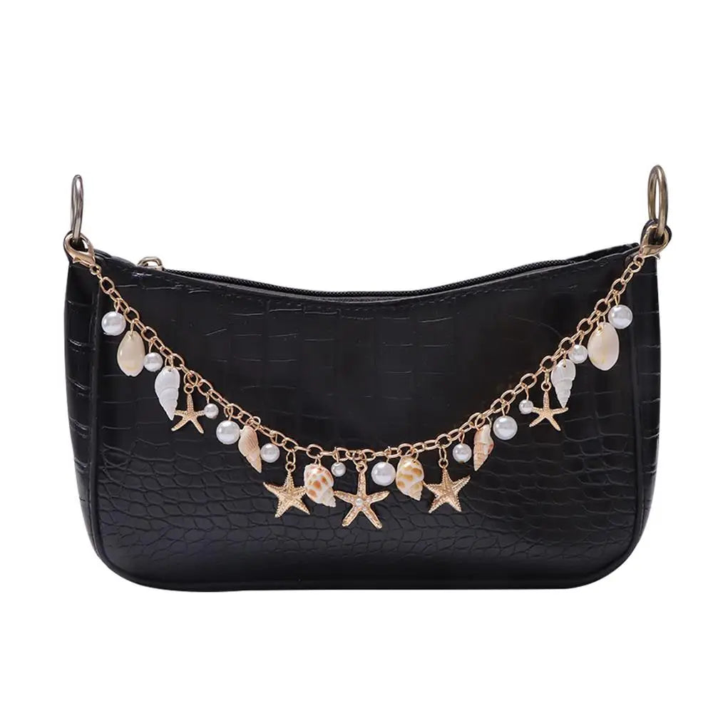 Black crocodile print handbag with a gold beaded chain and dangling charms