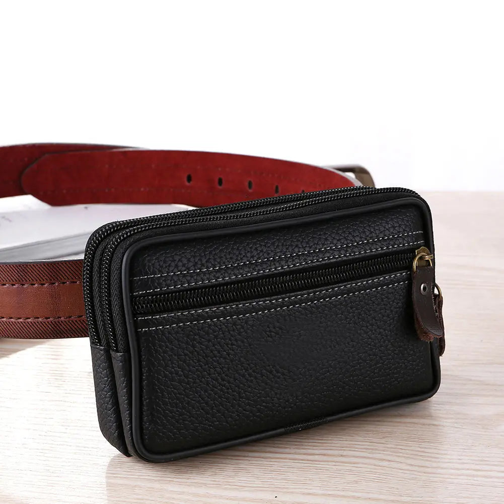 Black PU leather multi-function waist bag with a zipper and a brown leather strap resting on a wooden surface.