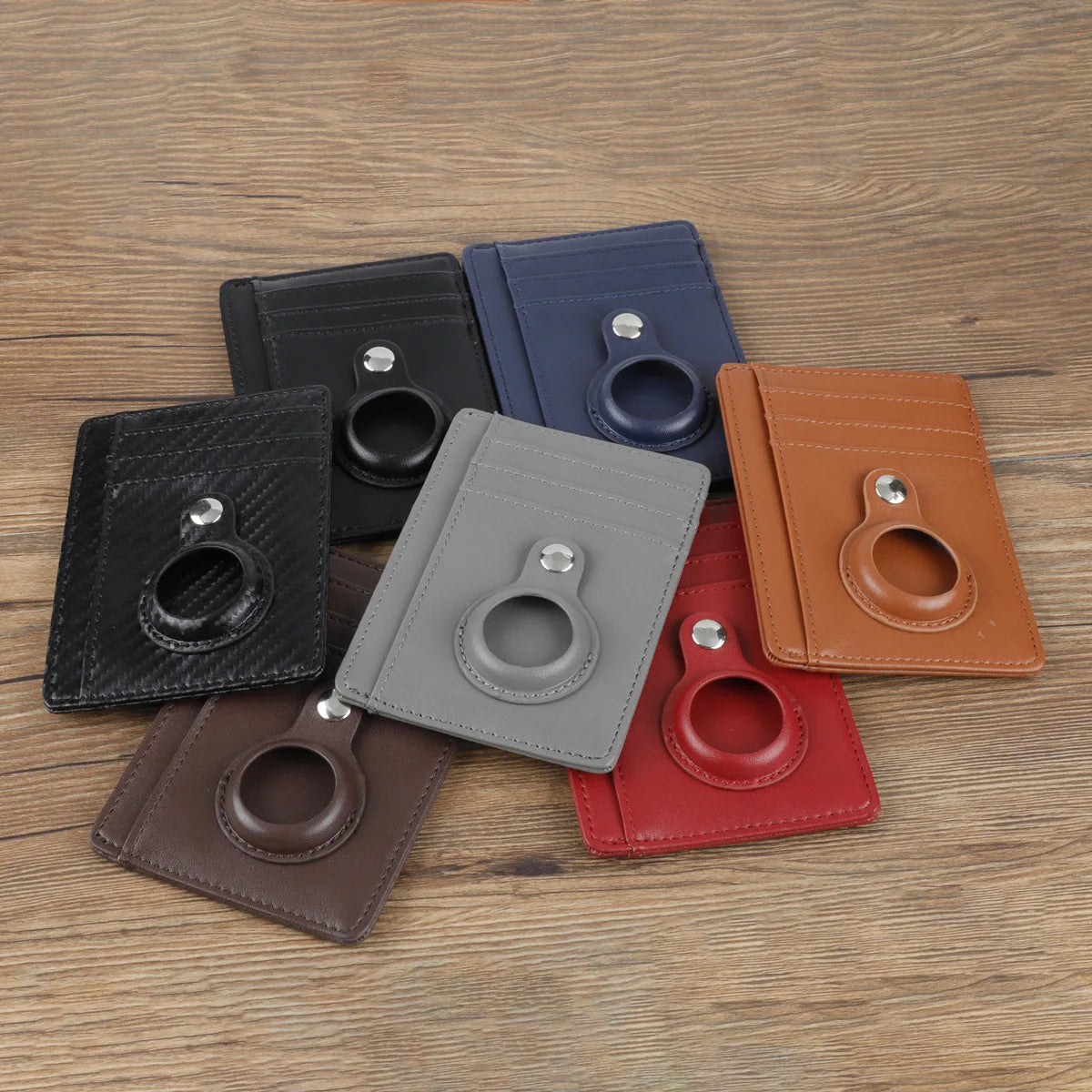A collection of leather card holder wallets in various colors including black, blue, brown, and red, displayed on a wooden su