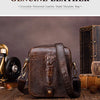 A dark brown crocodile patterned leather small shoulder bag resting on a wooden surface.