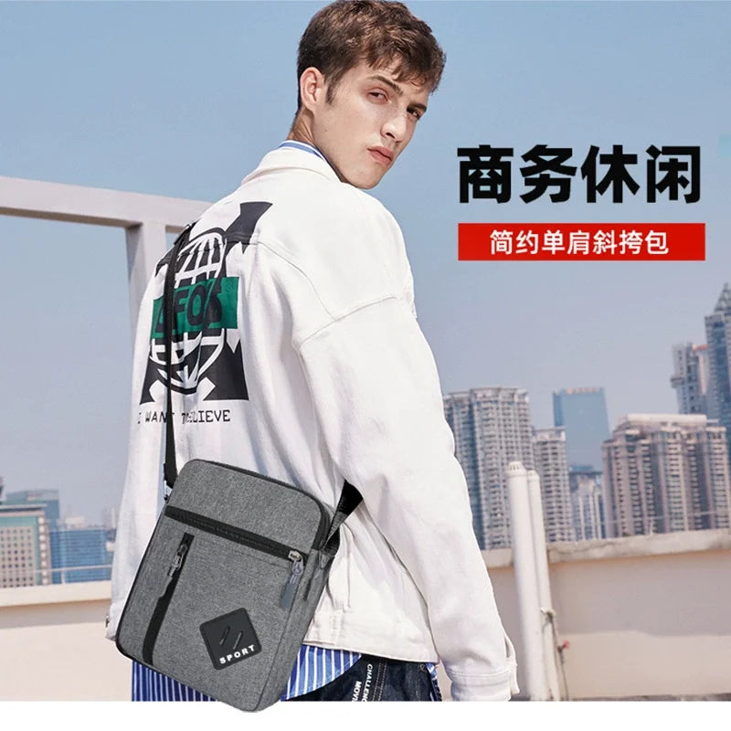 A young man is holding a gray sports sling bag in front of a city skyline.