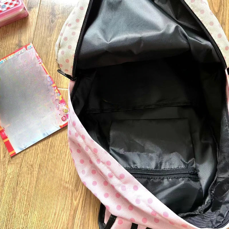 Sac à dos rose et blanc à motif de chat, ouvert, montrant l'intérieur noir.