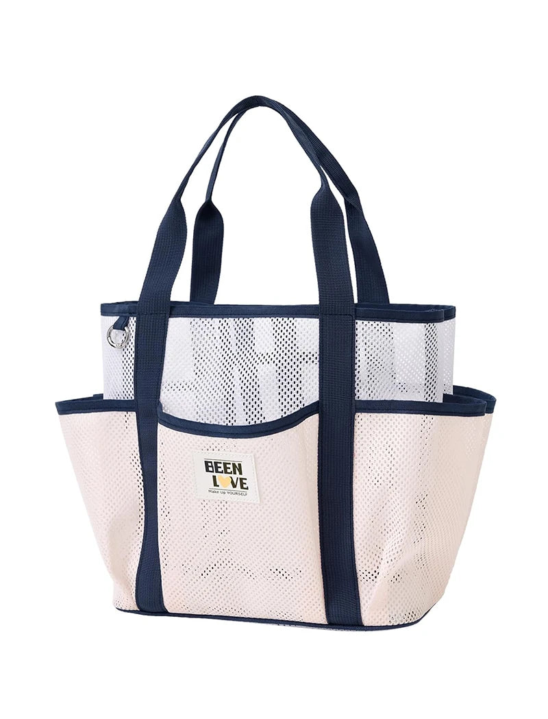 A beige mesh beach tote bag with dark navy handles and trim.