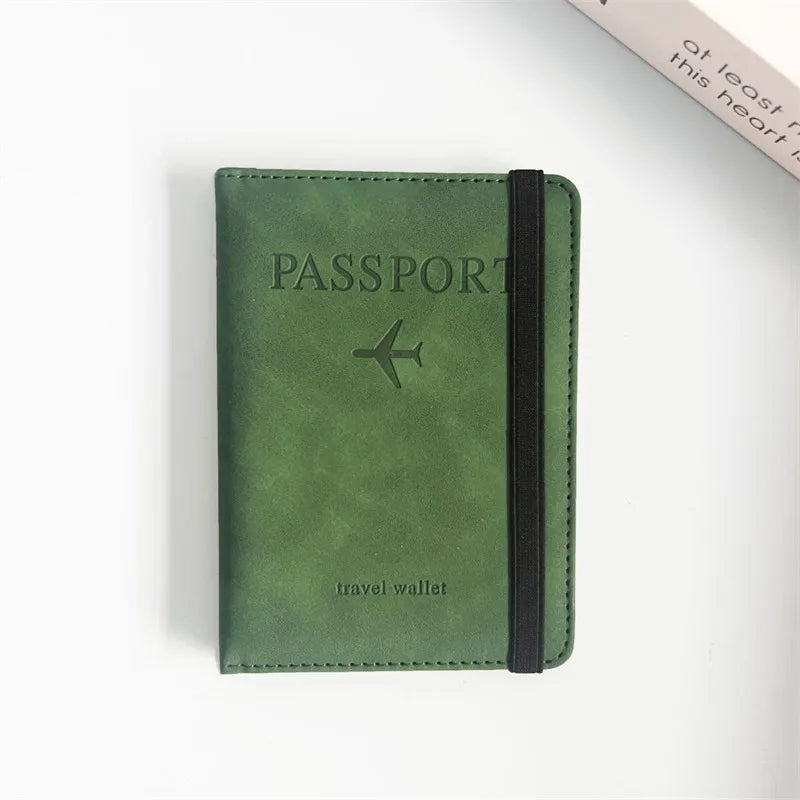 A dark olive green passport wallet with a black strap and embossed text on the cover.