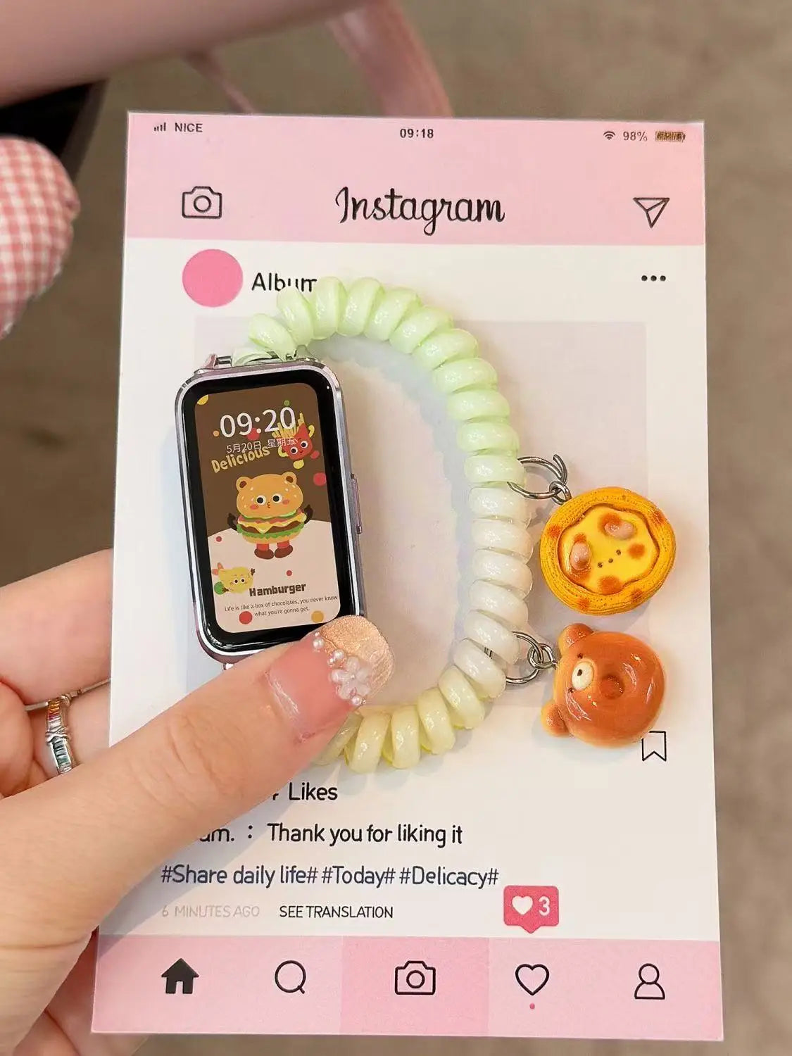 A close-up photo shows a white elastic watch strap wrapped around a smartphone displaying an Instagram post.
