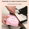 A pink portable pouch for storing sanitary napkins is being held by a hand, shown next to a black and white bag.