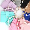 A collection of silicone bead and leather card wallets in various pastel colors like pink, mint green, blue, and beige.