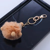 A small, fluffy, light orange-brown animal figurine attached to a gold metal swivel lobster claw clasp.