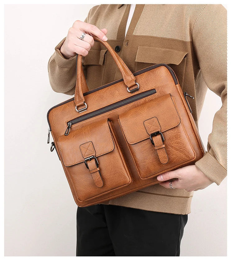 A person holds a tan brown PU leather business briefcase bag against a light colored shirt.
