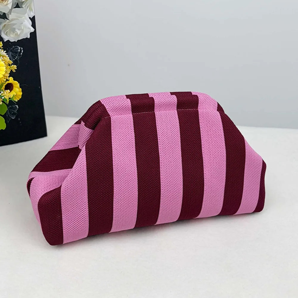 A makeup bag with a striped pattern in shades of pink and deep burgundy.