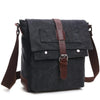 A dark gray canvas messenger bag with brown leather accents and straps.
