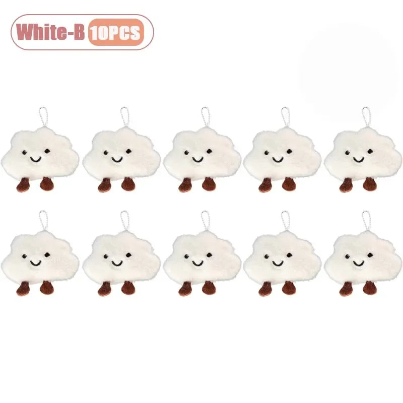 Ten white cloud-shaped plush keychains and brooch pins with small stitched faces