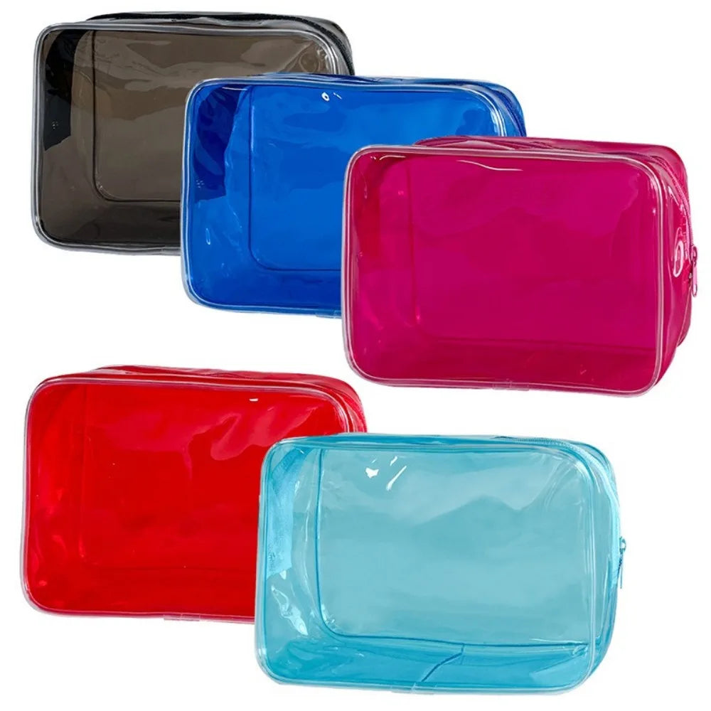A collection of five transparent PVC travel makeup bags in black, blue, pink, red, and light blue.