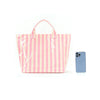 A pink and white striped tote bag with pink handles next to a light blue smartphone.