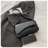 A dark gray blazer with a black leather flap shoulder bag and a smartphone resting on a white surface.