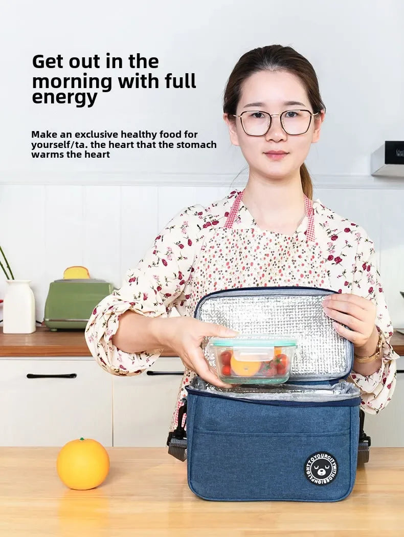 A woman holds an insulated portable lunch bag on a wooden table, demonstrating its use for healthy food.