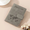 A grey passport wallet with a leather texture and a world map design is shown on a light background.