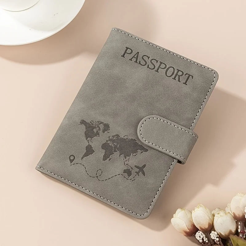 A grey passport wallet with a leather texture and a world map design is shown on a light background.
