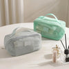 A light mint green mesh cosmetic organizer pouch is displayed on a white surface.