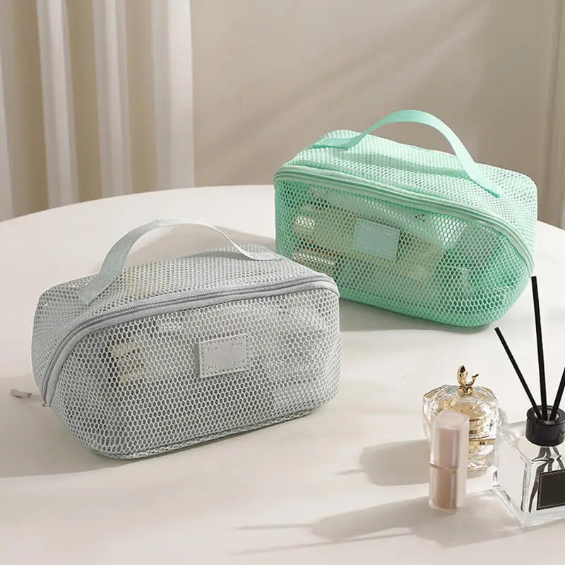 A light mint green mesh cosmetic organizer pouch is displayed on a white surface.