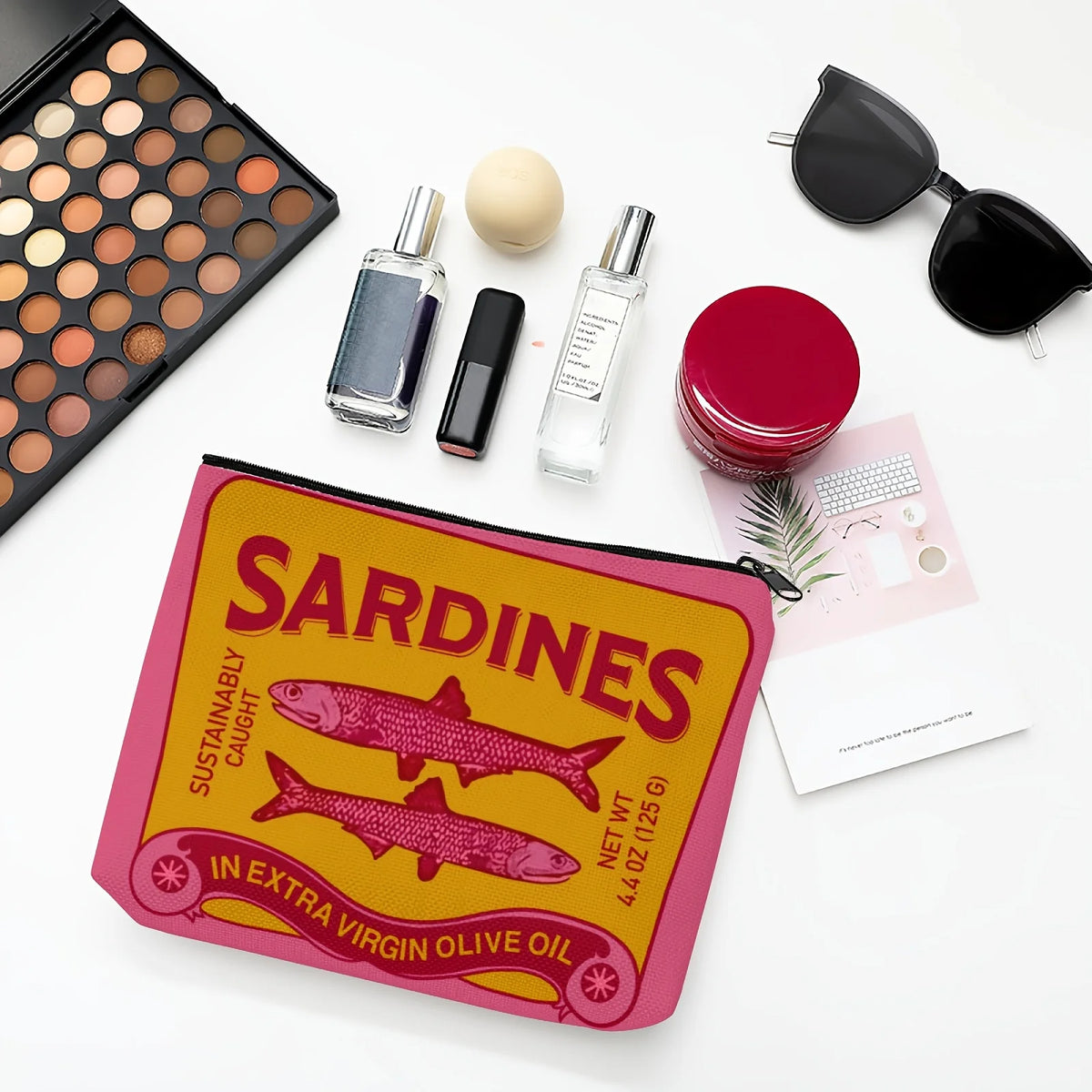Pinkes und gelbes Beutelchen mit Sardinen, Vintage-Olivenöl-Make-up-Produkten und -Accessoires.
