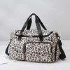 A beige leopard print travel duffel bag with a separate shoe compartment and black straps.