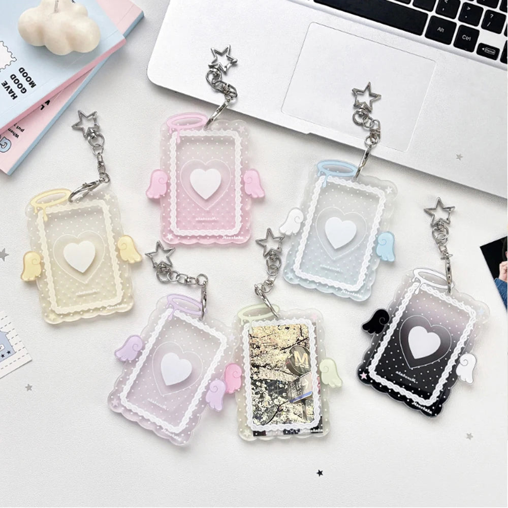 A collection of acrylic photocard holders shaped like angels with wings and hearts in various pastel colors