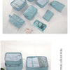 A collection of seven light blue fabric storage bags and organizers arranged on a white surface.