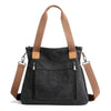 A dark gray canvas tote bag with tan leather straps and zipper details.