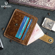 A brown genuine leather card wallet is shown open, displaying a blue card and a pink banknote on a dark gray surface.