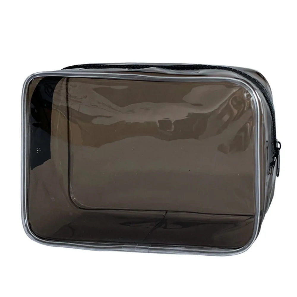 A transparent PVC travel makeup bag with a black zipper closure.