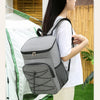 A gray insulated lunch backpack with a waterproof shell is worn by a woman outdoors.