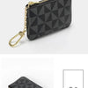 Black geometric mini coin purse with gold chain shown against a white background.