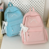 A pink embroidered backpack and a light blue embroidered backpack are displayed on a white surface.