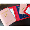 A stack of pink, red, and blue PU leather passport holders with card slots displayed on a dark surface.